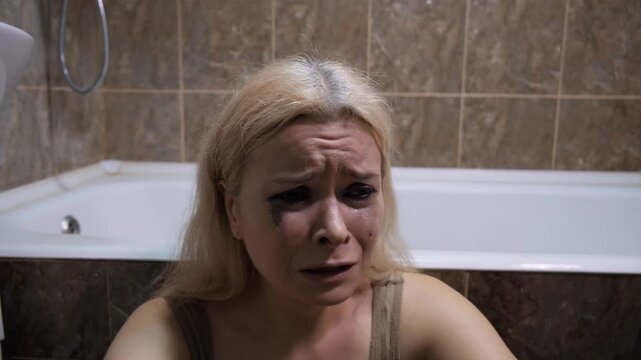 Mental Problem, Psyche Health, Loneliness or Abused. Blonde Woman In Bathtub Crying, Tears Streaming, Mascara Smudges, Pain, Sad Gaze, Tiled Bathroom, Closeup Of Anguish. Despair, Depressed, Emotional