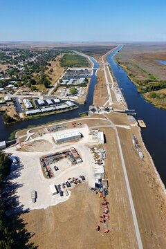 Aerial view of the Okeechobee Waterway slicing through the landscape, a ribbon of blue contrasting with the golden fields, Lake Harbor, Florida, United States.