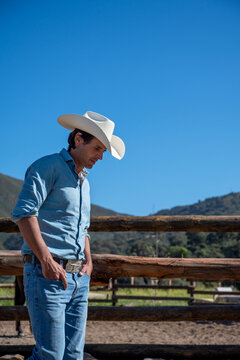 Reflective Cowboy walking on mountain ranch