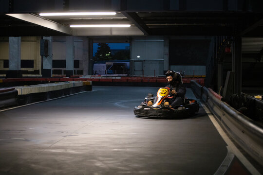 A go-kart driver on an indoor racing track