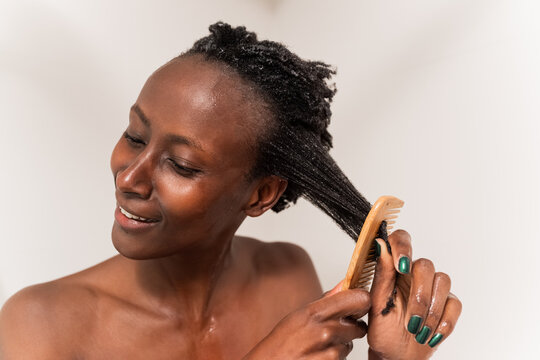 Woman brushing hair in shower 