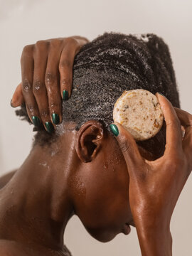 Woman applying shampoo on her hair in shower 