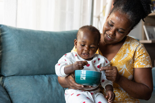 A woman feeds her baby cookies at home
