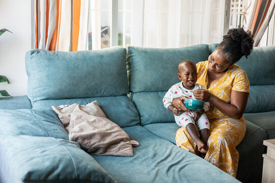A woman feeds her baby cookies at home