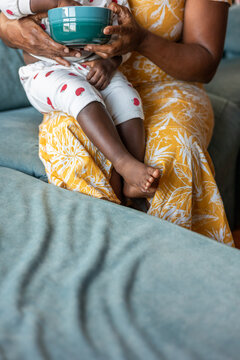 A woman feeds her baby cookies at home