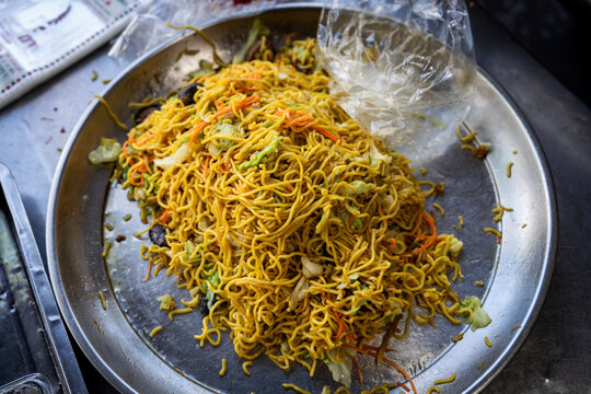 A pile of yellow vegetarian noodles at a street food vendor in Bangkok