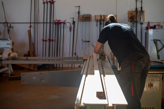 Hands fixing screw in wood workshop 