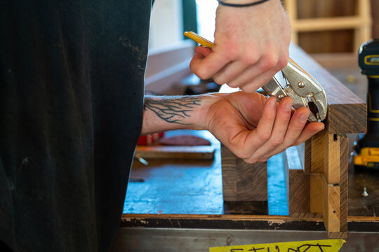 Hands fixing screw in wood workshop 