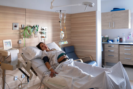 Laboring Pregnant Woman In Hospital Bed Surrounded By Equipment