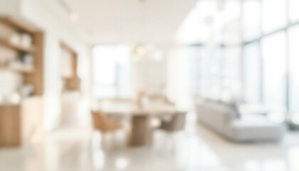 Interior of a modern dining area with blurred view of furniture, large windows, and light colors. The space appears spacious and stylish, featuring wooden elements.