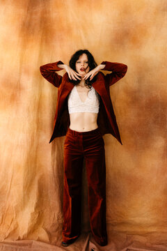 Woman posing in velvet suit and lace bralette