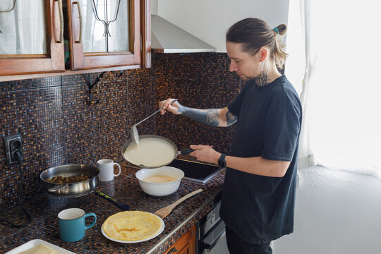 Young man frying pancake