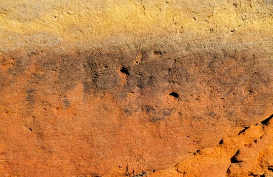 Abstraktes Motiv mit orange-braun-gelber alter Backsteinfassade als Hintergrund