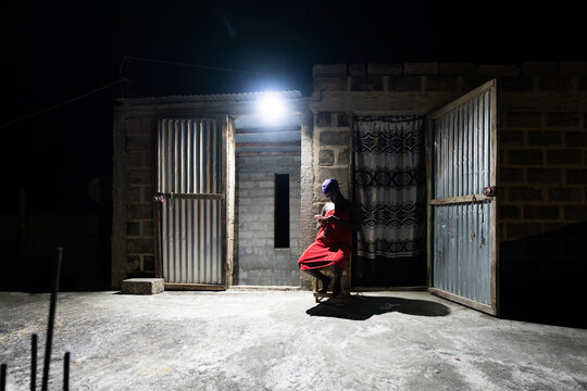 African woman using cell phone at night in Senegal