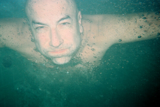 Man diving Underwater in a Clear Pool 