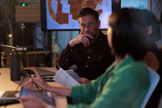 Business meeting with map data on screen.