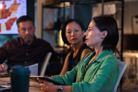 Business meeting with diverse team discussing data.