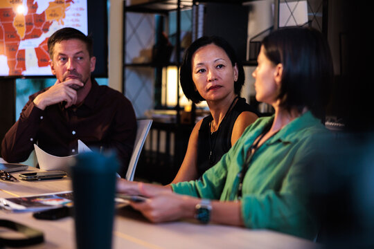 Business meeting with map display, focused discussion.