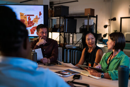 Diverse team collaborates on data analysis in a modern office.