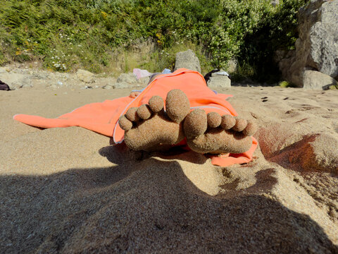 feet are covered in sand.