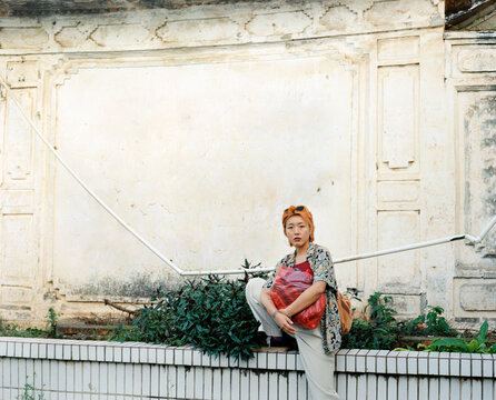 Asian woman  with one foot on ledge