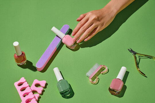 Nail care tools are arranged on a green backdrop