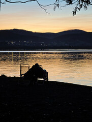 Couple enjoying romantic sunset on lake beach © larrui