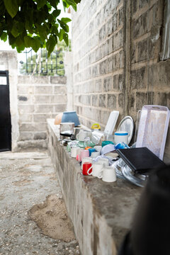 Washed dishes drying on outdoor stone ledge in Senegal