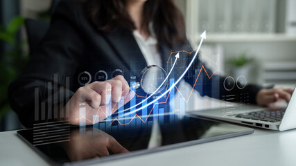 A business professional engages in financial analysis using a digital tablet, showcasing futuristic...