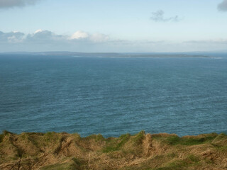 Amazing scenery of Cliff of Moher in county Clare. Famous landmark in Ireland with stunning nature views on the ocean and rock formation and Aran island. Travel and tourism gem and attraction.