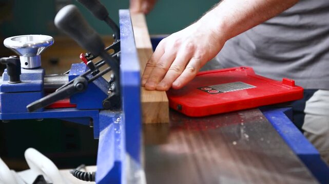Carpenter operate electric jointer Planer remove excess wood with. Wood shaping, precision cut, workshop tool, material trim, professional skill, surface smoothing
