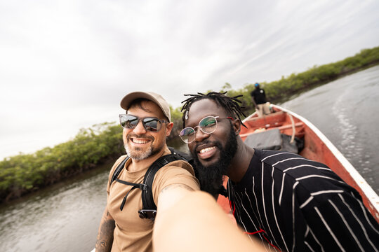 Friends taking selfie on boat during Senegal river tour
