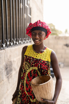 Senegalese woman smiling holding traditional wooden mortar