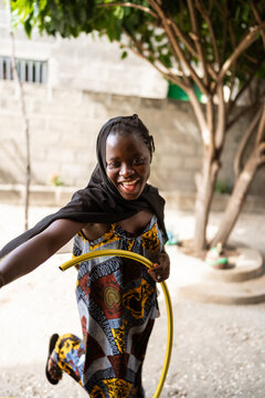 Joyful African girl playing with hula hoop in Senegal