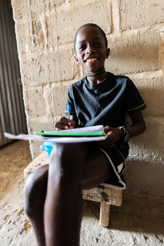 African boy student writing and smiling in Senegal