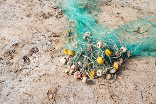 Traditional fishing net with colorful floats on sand in Senegal