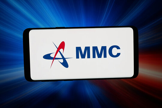 Stuttgart, Germany - 02-27-2026: In this photo illustration, the logo of Malaysian company MMC Corporation Berhad is displayed on a smartphone in front of abstract background on computer screen.
