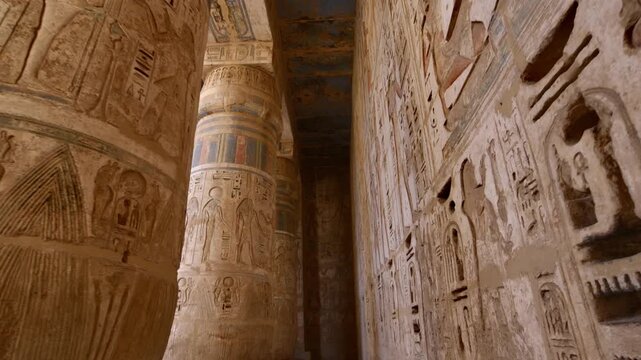Medinet Habu temple painted ceiling with vulture goddess Nekhbet and hieroglyphs in red orange colors in Luxor Egypt, ancient Egyptian astronomical decorations and cartouches .