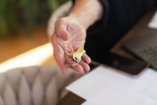 Hand holding house keys indoors