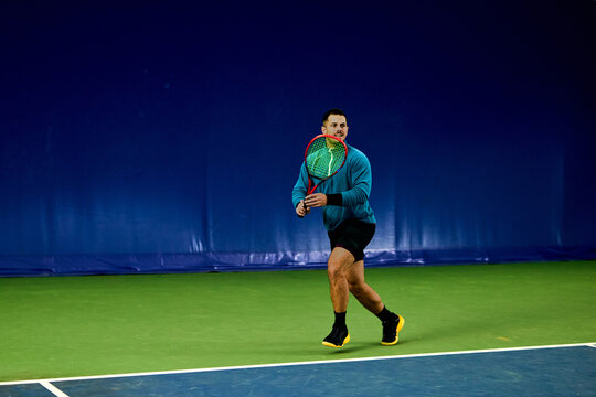 Man gets ready to hit the tennis ball.