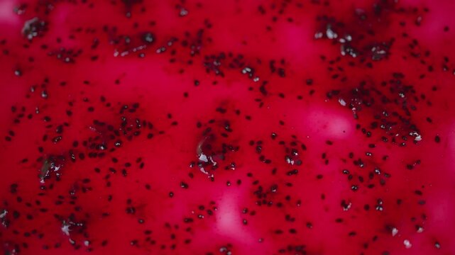 Closeup red currant jam surface, tiny black seeds scattered across glossy ruby gel, shimmering highlights and syrup pockets, macro food texture for packaging and recipe backgrounds