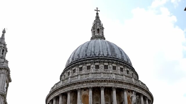 A grand cathedral with a dome and clock tower against a cloudy sky