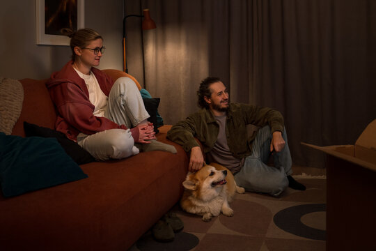 Couple relaxing at home with dog after unpacking