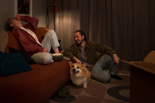Couple laughing together at home with their dog