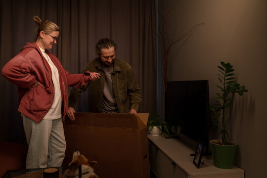 Couple unpacking new television at home