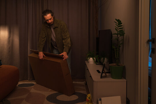 Man setting up new television at home