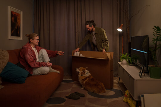 Family unpacking new television with dog at home
