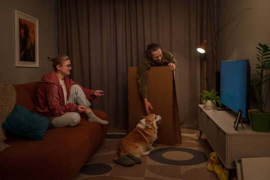Family setting up television at home with dog