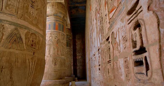 Medinet Habu temple colonnade with hieroglyphic inscriptions and relief carvings in Luxor Egypt, massive sandstone columns with papyrus capitals  Mortuary Temple of Ramesses II. Downscaled from 6k.