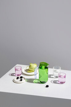 Minimalist table setting with green pitcher and blackberries